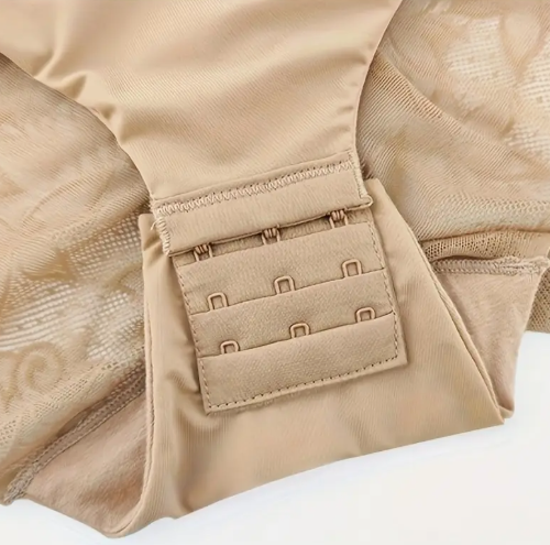 Seamless nude bodysuit shaper from The Seventh Muse with a supportive underwire bra top and subtle sheer mesh slimming panels at the hip  Close-up of beige body suit with hook and eye mechanism on a white  background