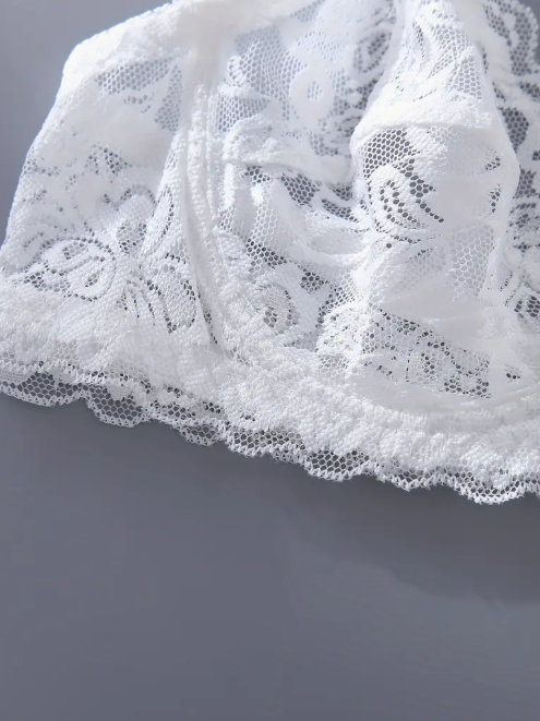 Close-up of white lace fabric on a gray background by The Seventh Muse