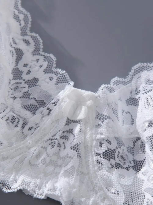 Close-up of white lace fabric on a dark background by The Seventh Muse