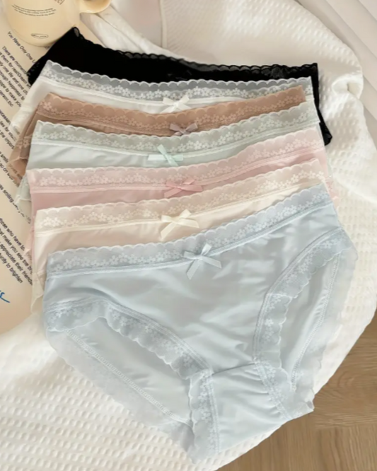 A collection of seven mid-rise thongs with lace trim in assorted pastel colors.