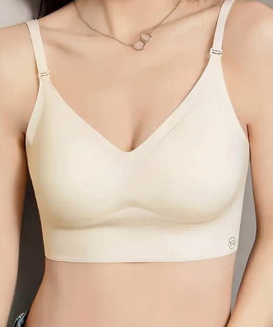 Beige backless bralette worn by a model on a plain background