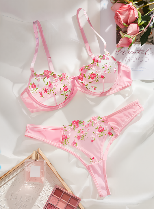Pink floral lingerie set on a white surface 