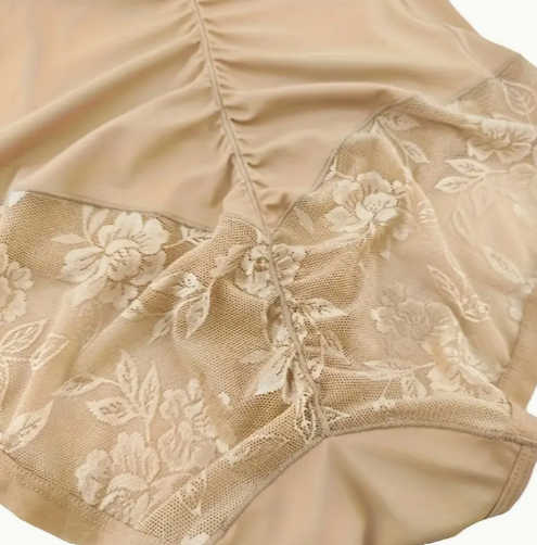 Beige lace lingerie with floral patterns on a white background by The Seventh Muse