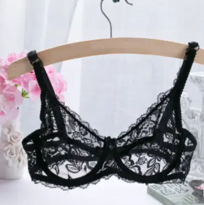 A black sheer lace underwire bra displayed on a wooden hanger, with floral lace detailing and adjustable straps.