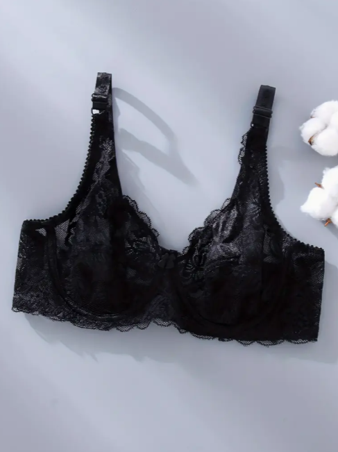 Black lace bra on a light gray background with cotton fibers by the Seventh Muse