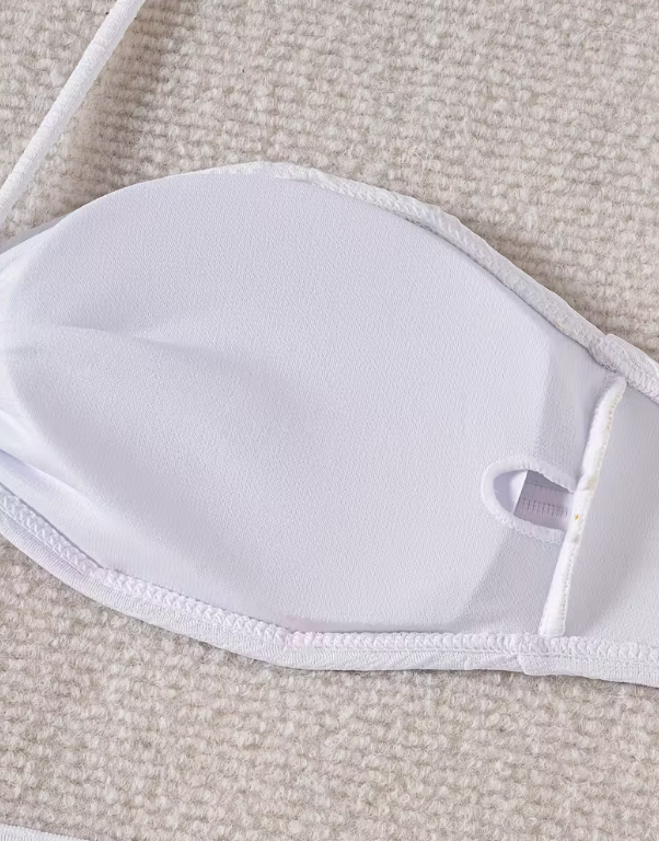 White three-piece bikini set for women featuring a starfish embellishment, halter neck bandeau top, matching bikini bottom, and wrap cover-up skirt – chic beachwear from The Seventh Muse.