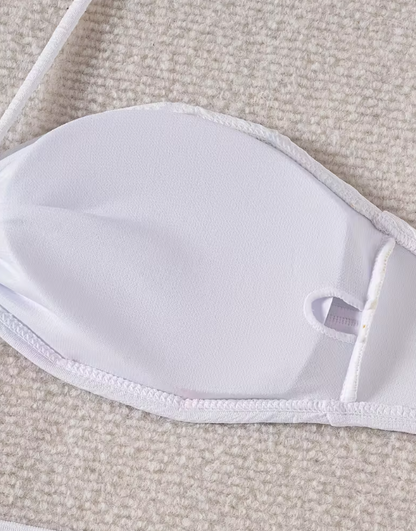 White three-piece bikini set for women featuring a starfish embellishment, halter neck bandeau top, matching bikini bottom, and wrap cover-up skirt – chic beachwear from The Seventh Muse.