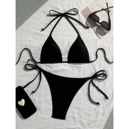 Black bikini set with bow details on a light background