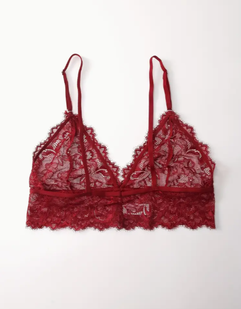 A red lace bralette with adjustable straps and a satin bow detail at the front.