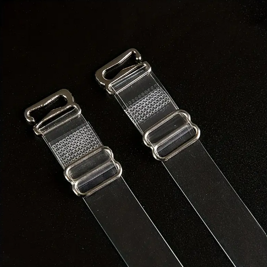 Close-up of two adjustable, transparent clear bra straps with silver-toned metal clasps and adjusters on a dark background.