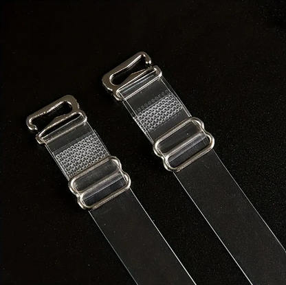 Close-up of two adjustable, transparent clear bra straps with silver-toned metal clasps and adjusters on a dark background.